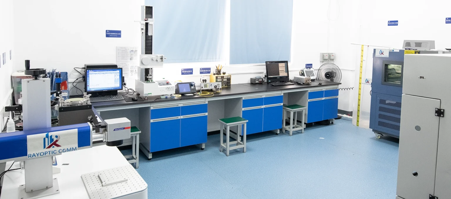 Overview of Rayoptic fiber optic testing laboratory with inspection workstations and environmental test chamber